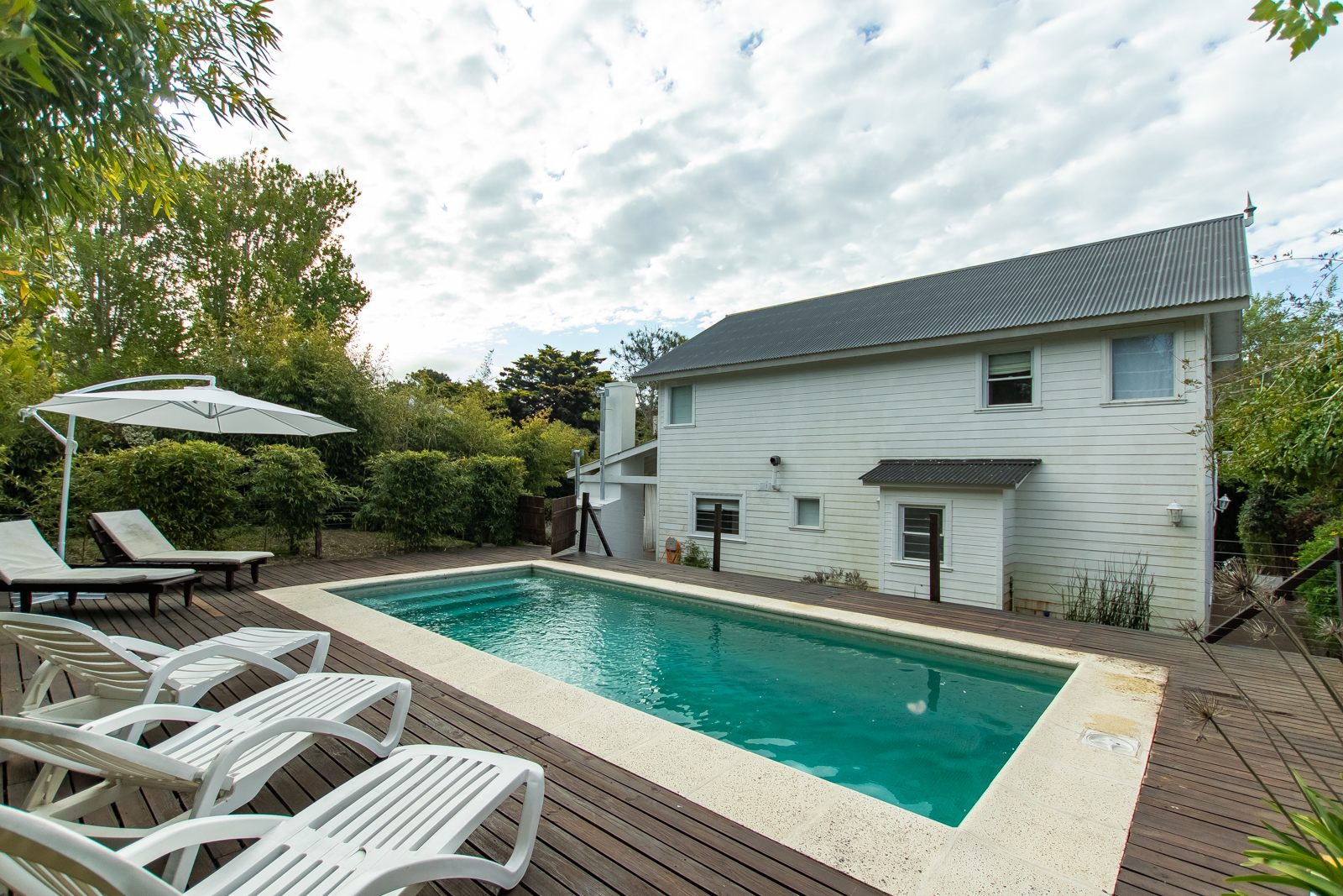Piscina de la Casa Blanca sobre el deck, con la casa detrás